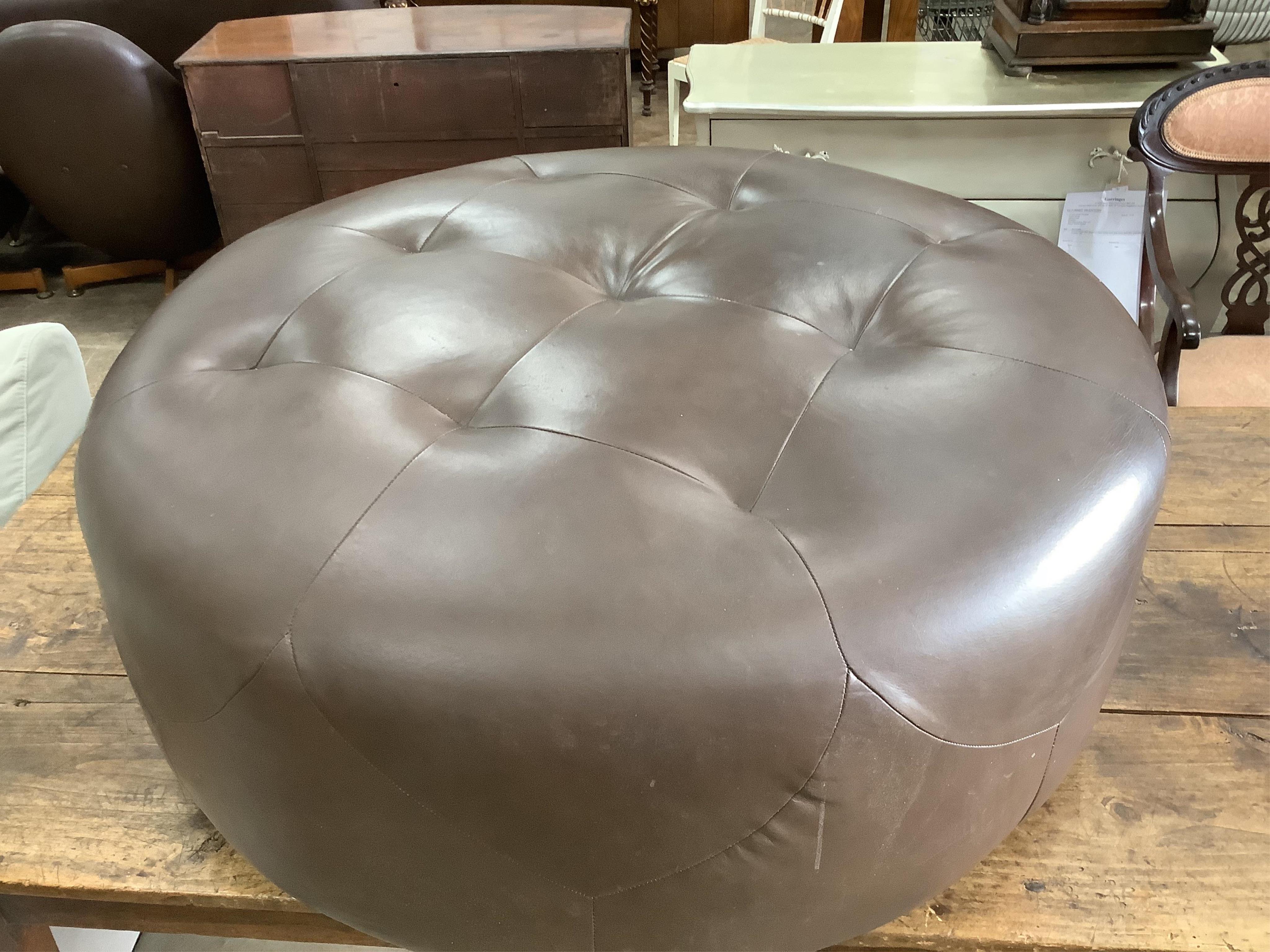 A circular brown leather footstool, diameter 100cm, height 36cm. Condition - fair